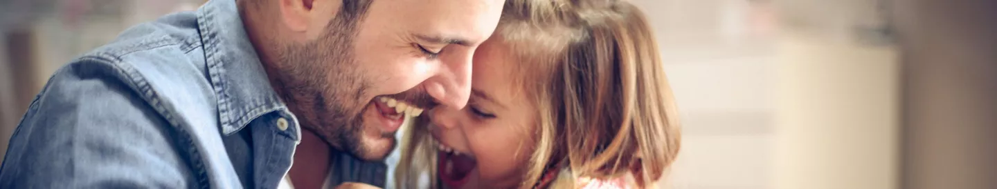 Padre e hija haciéndose cosquillas y riendo a carcajadas
