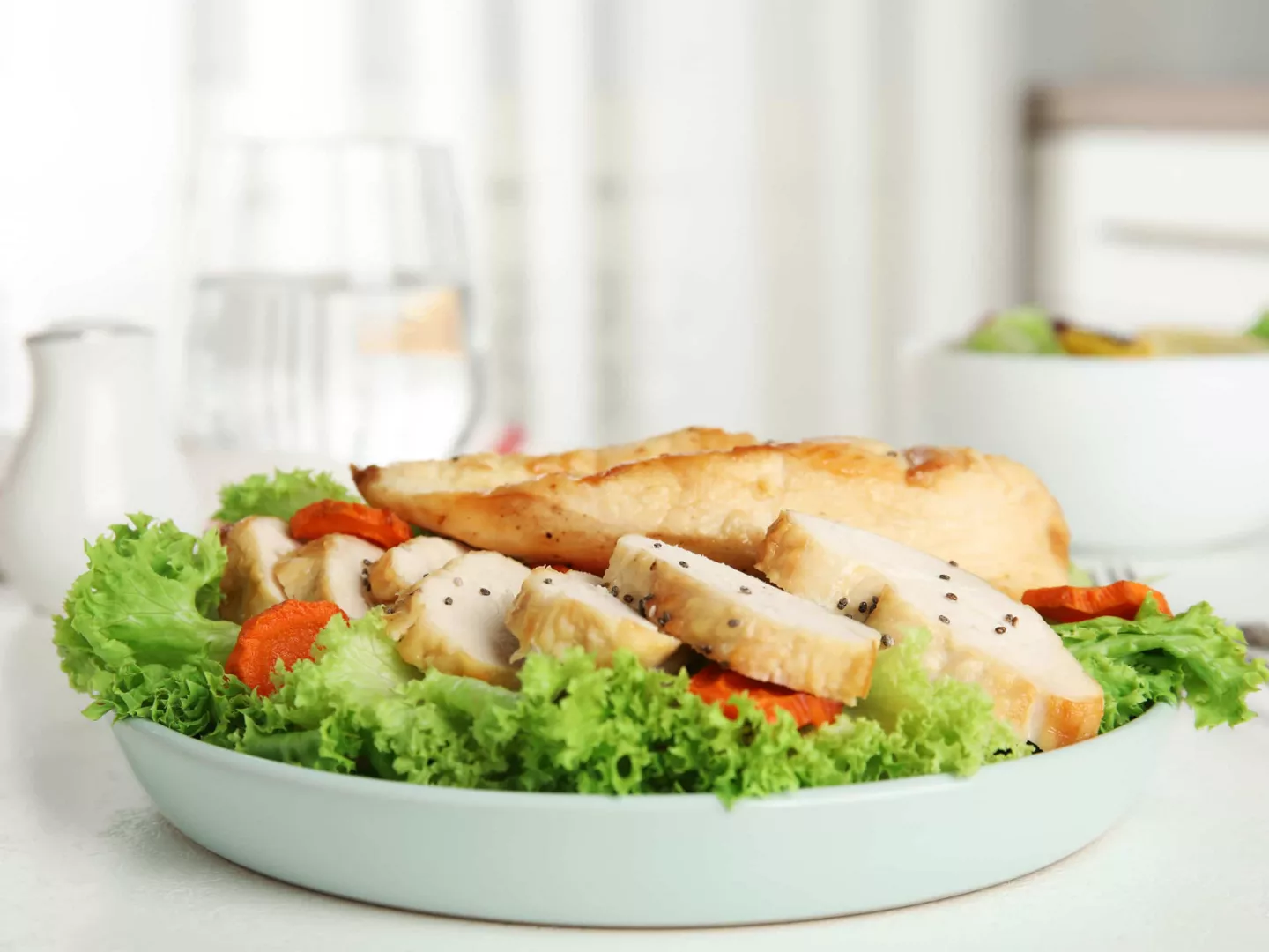 Pechuga de pollo fileteada sobre ensalada