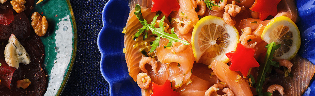Zalm carpaccio met gerookte zalm, kleine Hollandse garnaaltjes en kleine paprika sterretjes. ALDI