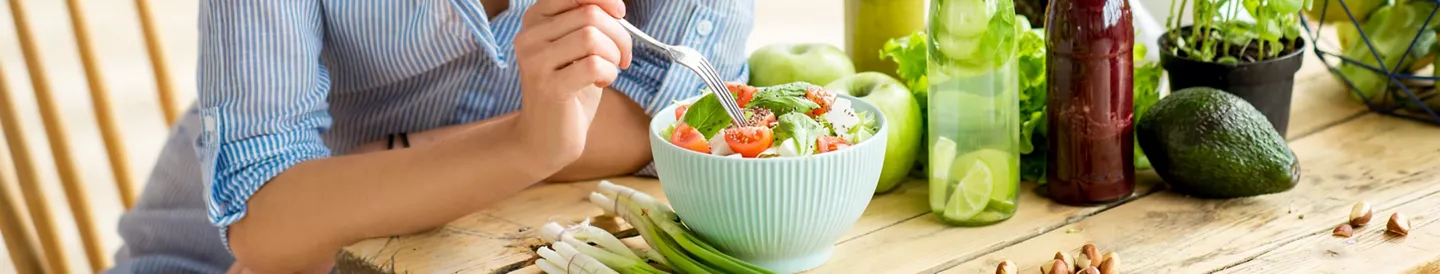 Mujer comiendo ensalada rápida mesa