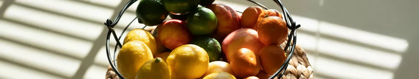 Frutas frescas en cesta, propensas a atraer moscas de la fruta