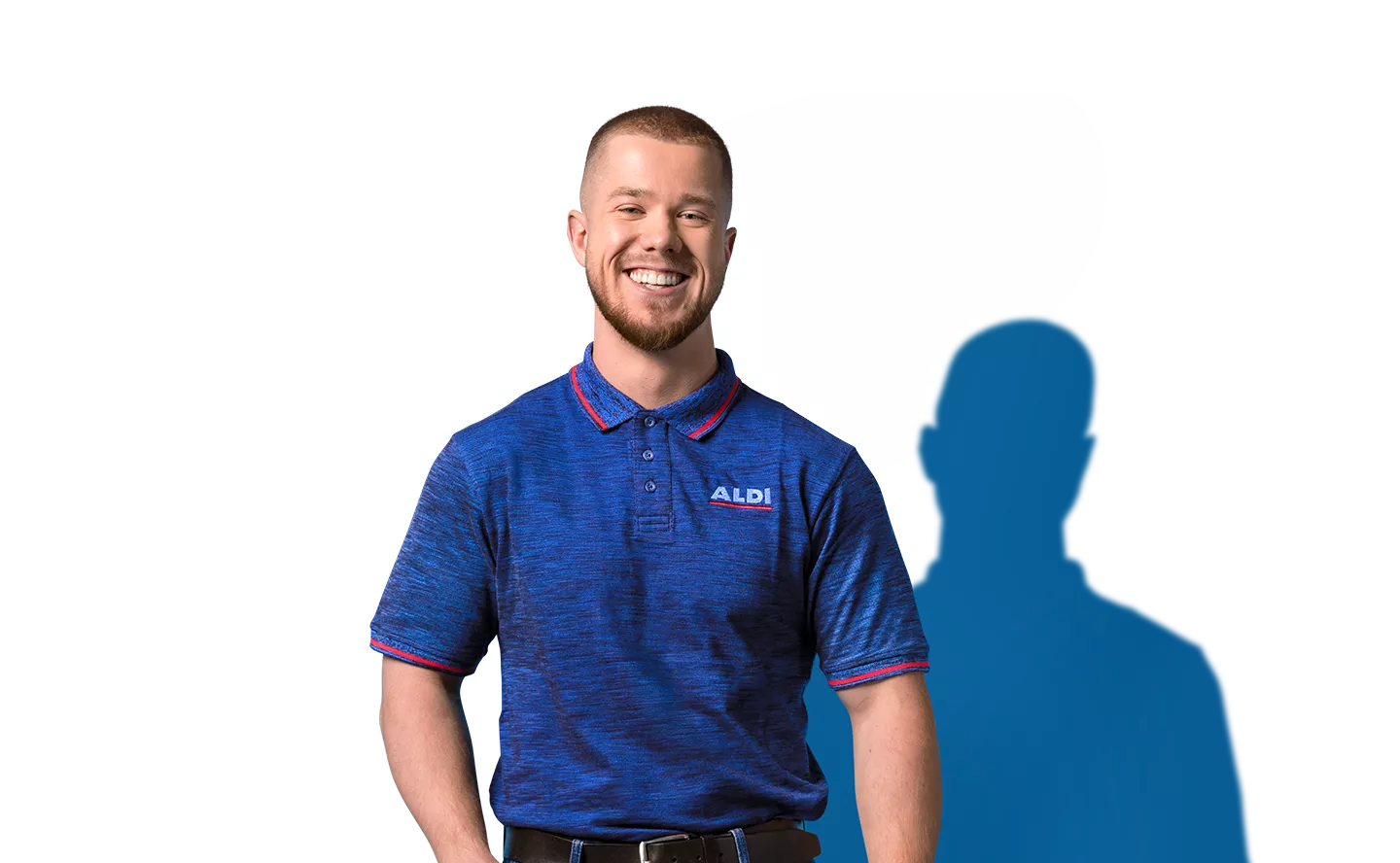 Ein lächelnder Mann mit einem blauen ALDI Poloshirt. Er blickt in die Kamera. 