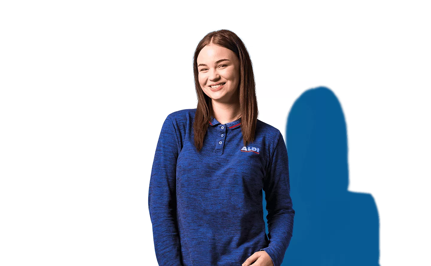 Porträt einer lächelnden Mitarbeiterin im blauen Shirt vor blauem Hintergrund