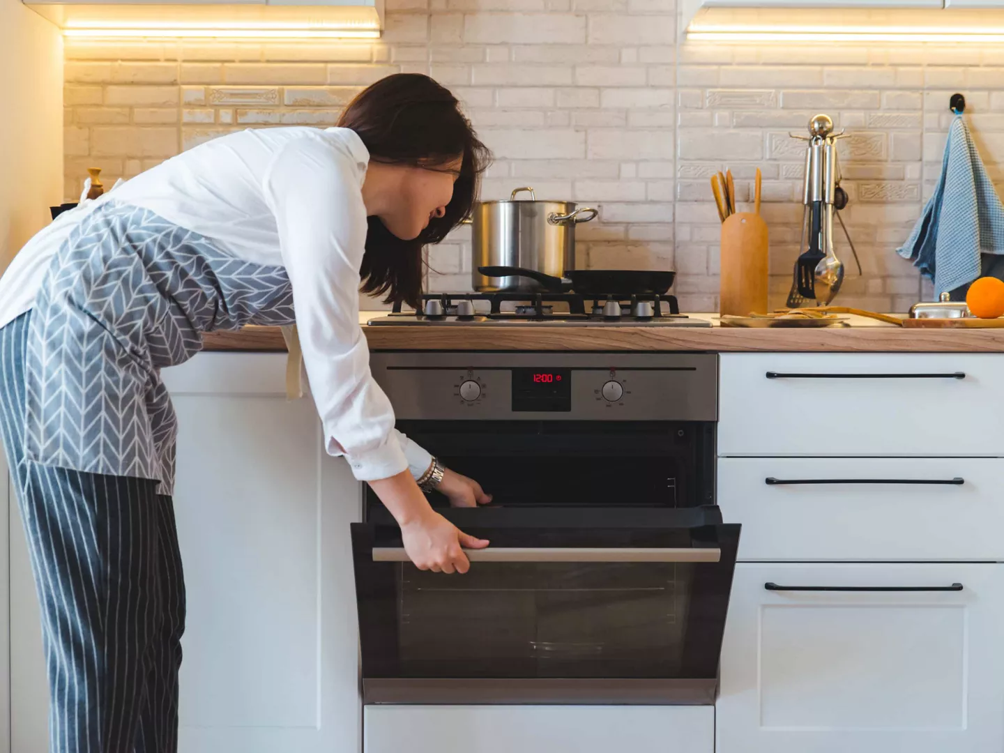 Mujer abriendo el horno para limpiarlo