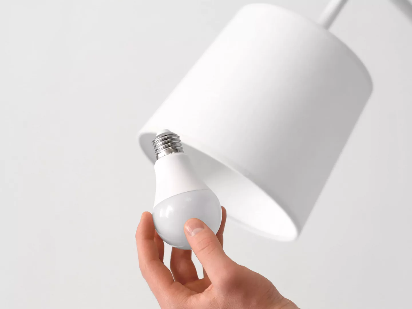 Persona ahorrando energía cambiando bombillas bajo consumo