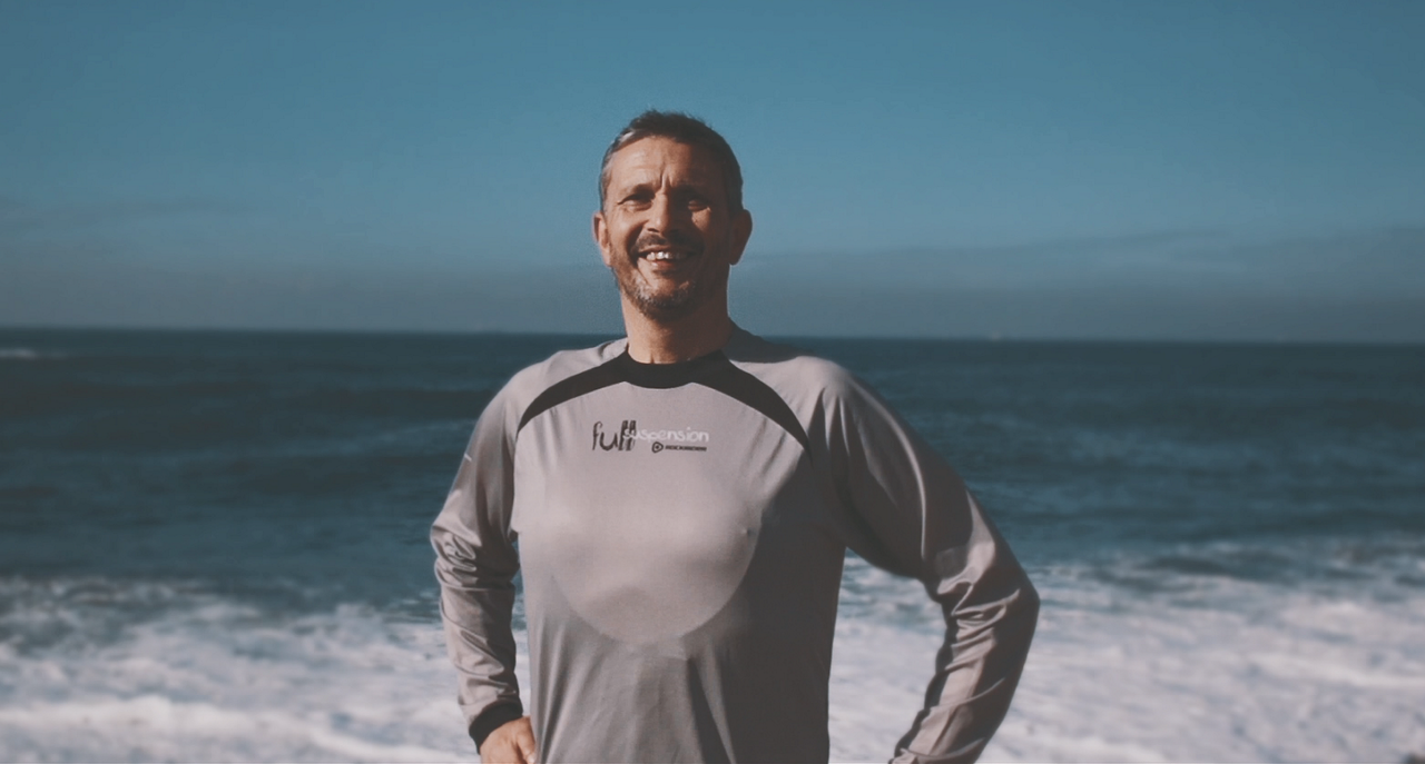 Smiling man standing by ocean shoreline