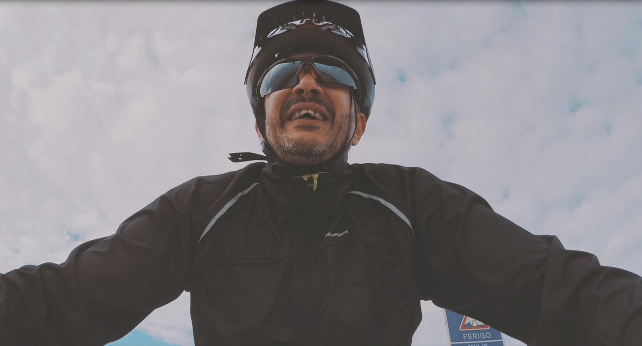 Cyclist in helmet riding under cloudy sky