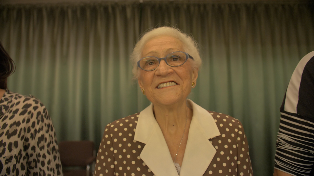 Smiling elderly woman in polka dot jacket