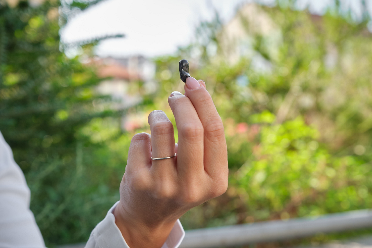Hand holding small black electronic device