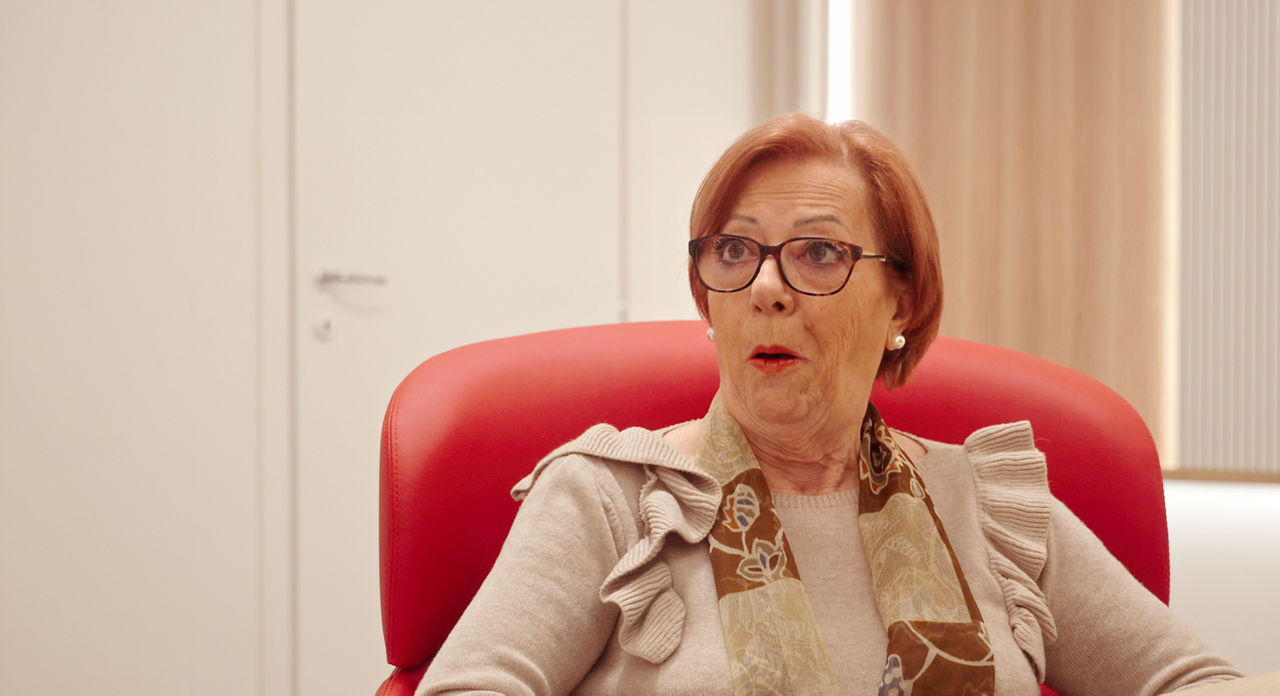 Surprised elderly woman seated in office