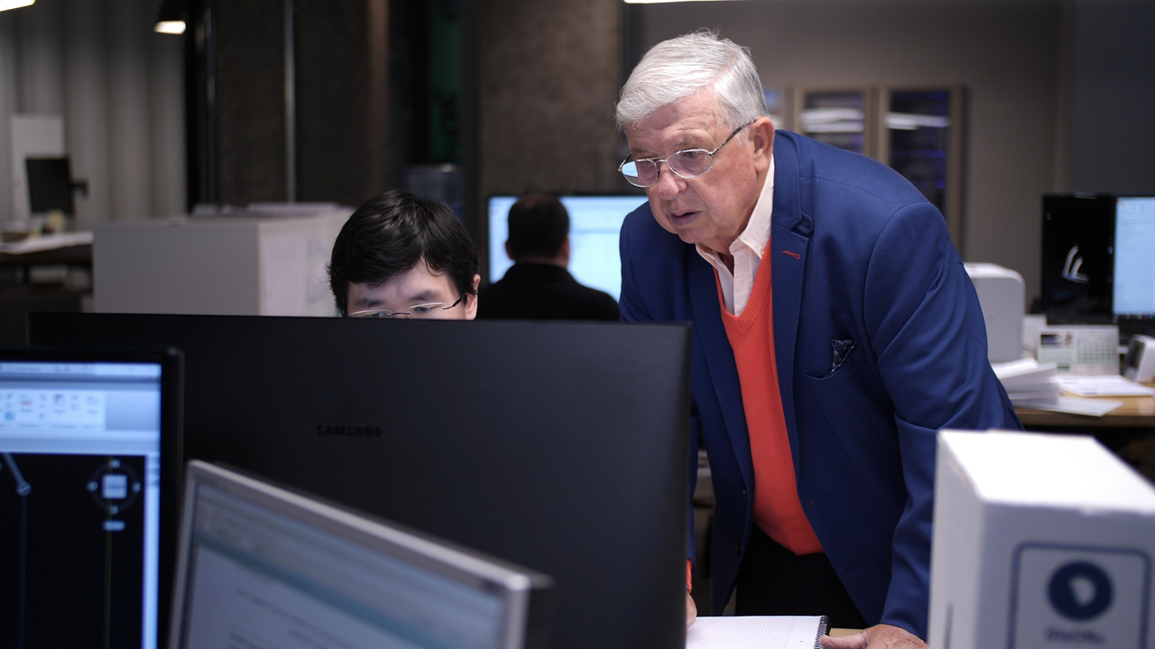 Senior manager mentoring colleague at computer