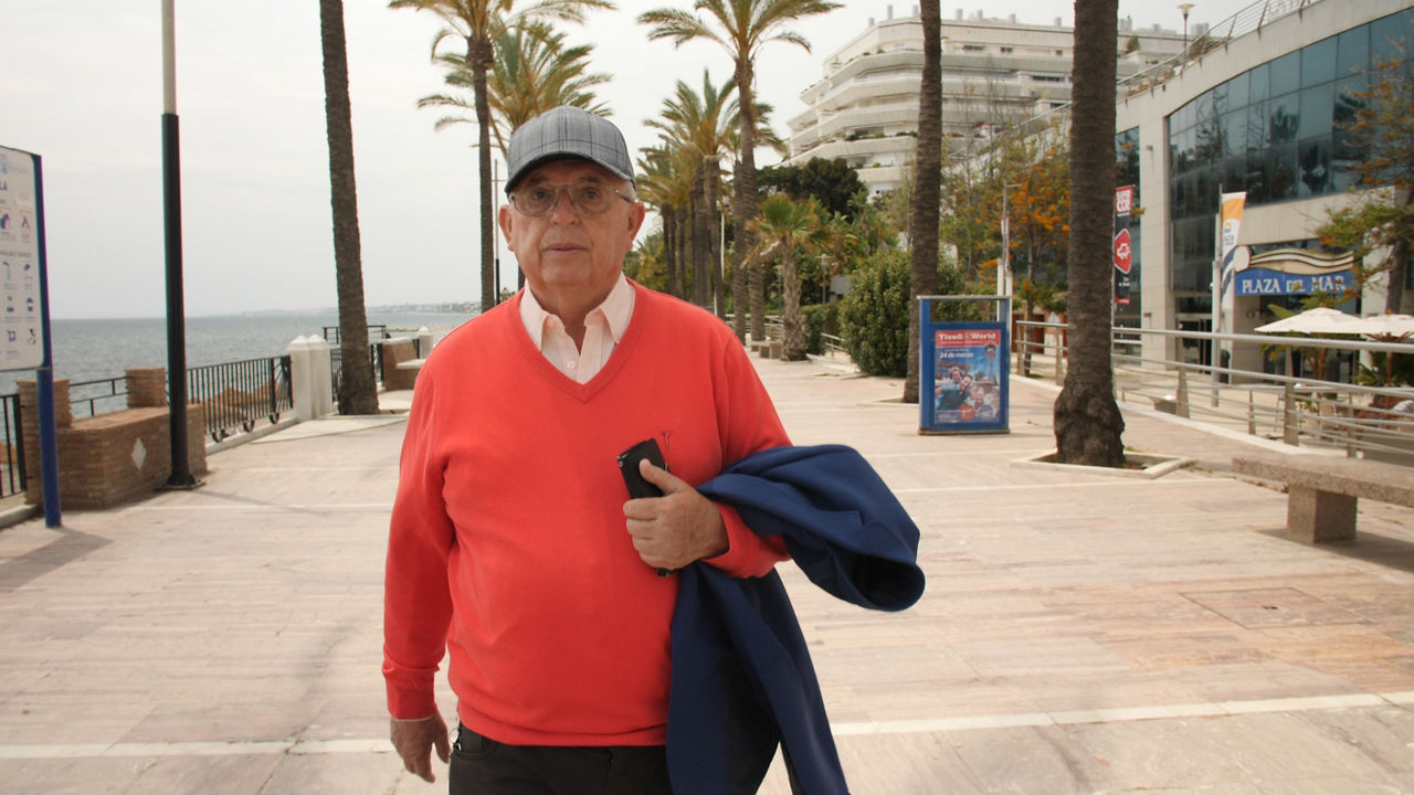 Senior man walking along seaside promenade