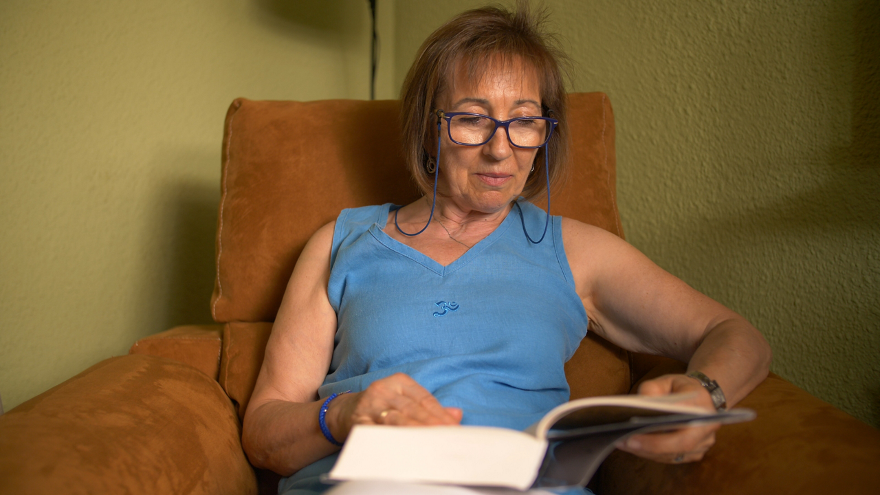 Older woman reading book in armchair