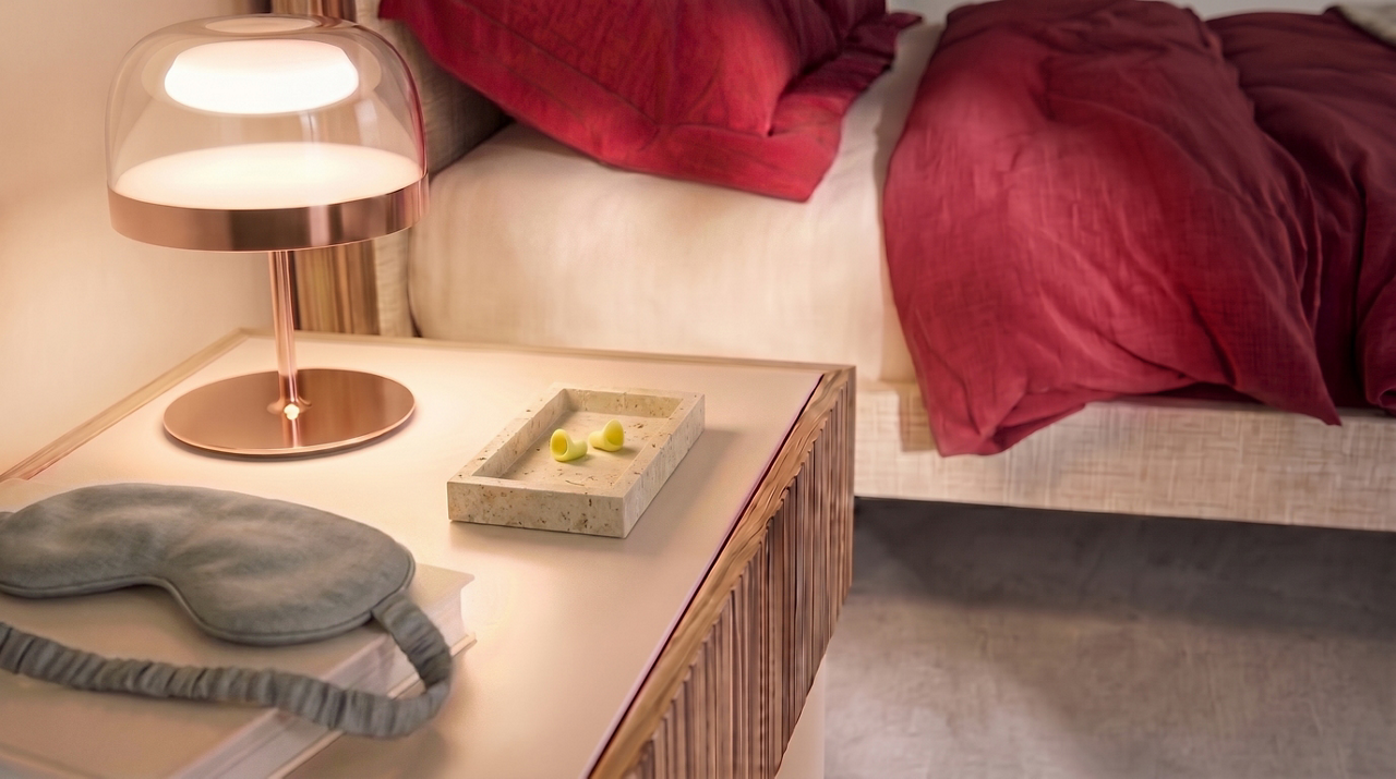 Cozy bedroom nightstand with lamp and linens