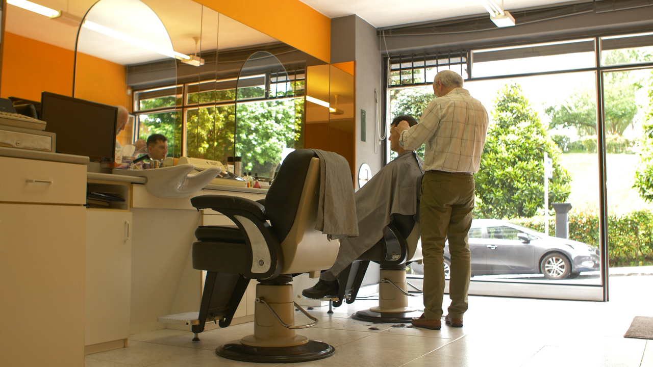 Barber styling client in bright salon