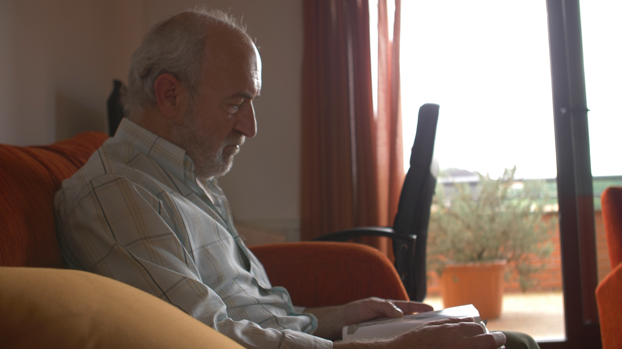 Older man reading quietly on sofa