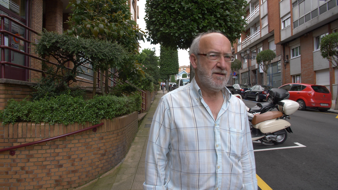 Older man walking along urban street