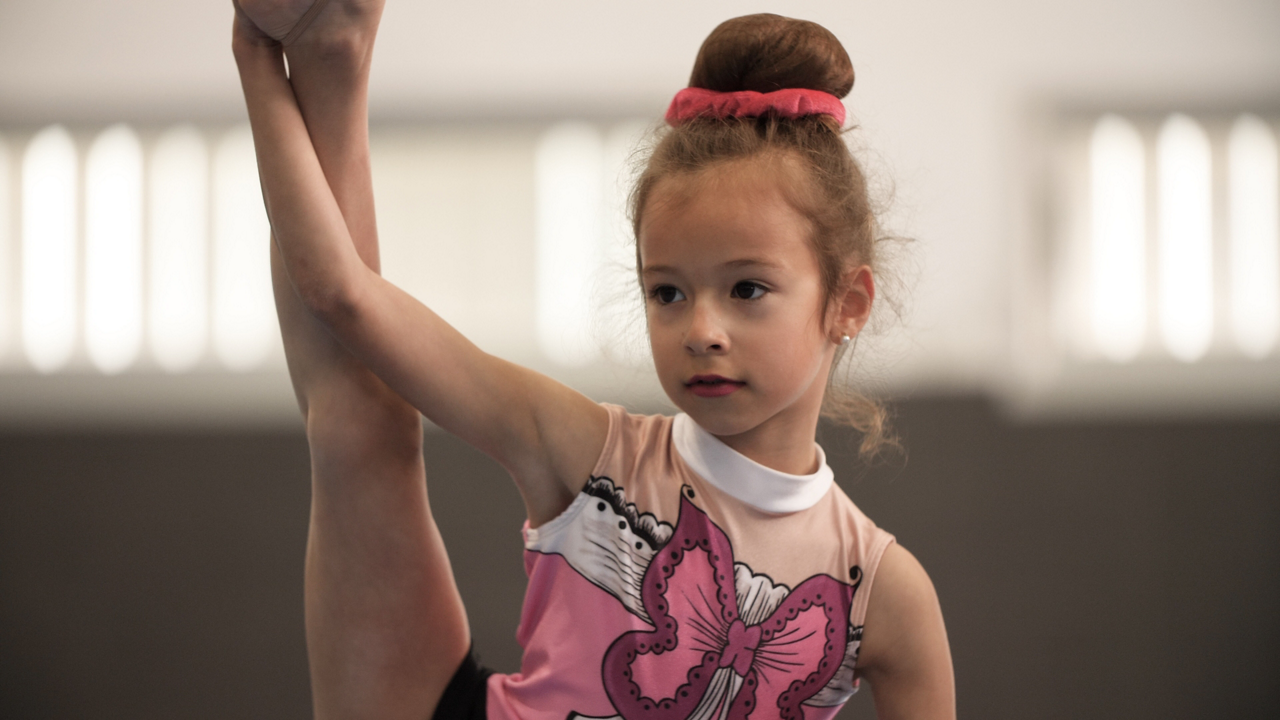 Young gymnast practicing leg stretch pose