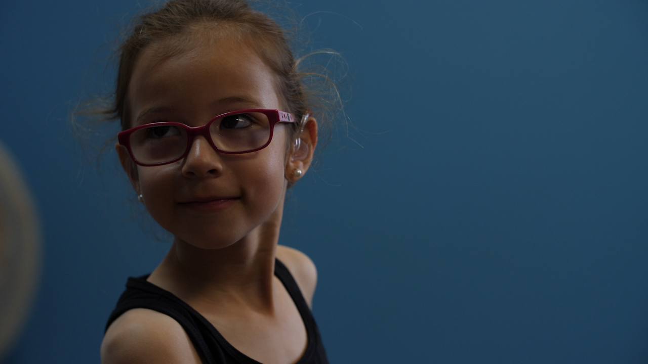 Smiling young girl with red glasses