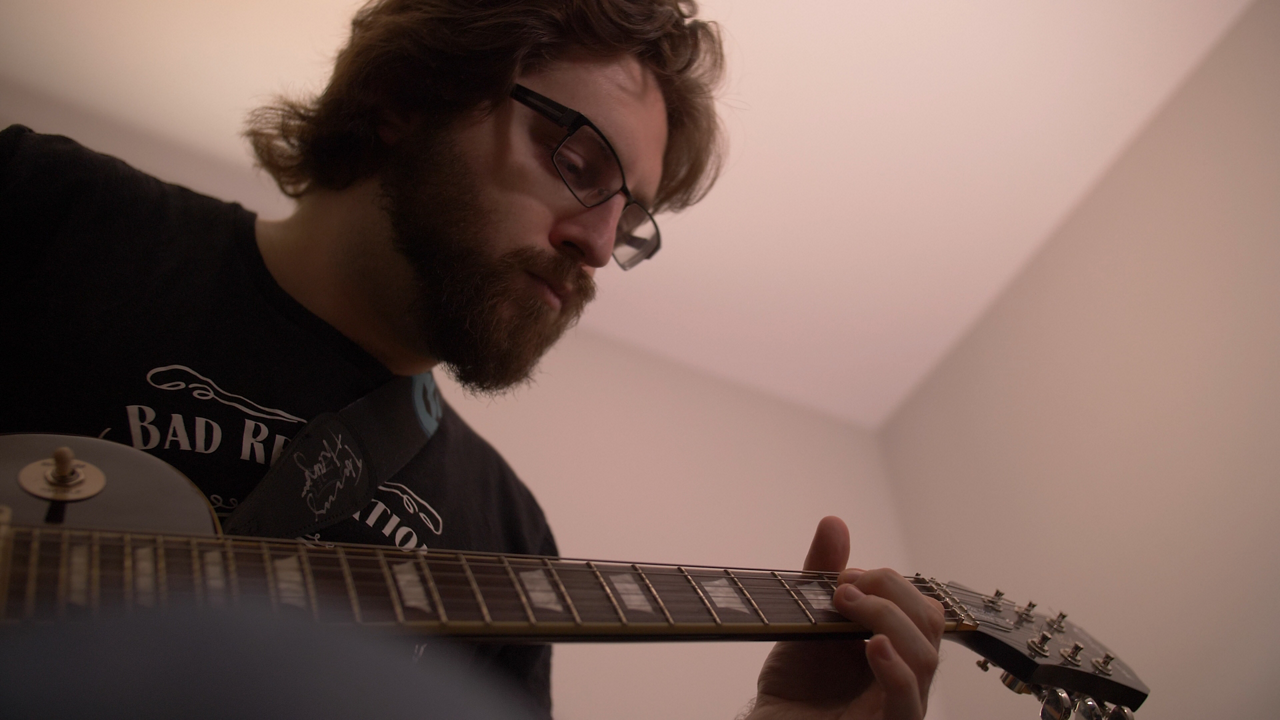Bearded musician playing electric guitar indoors