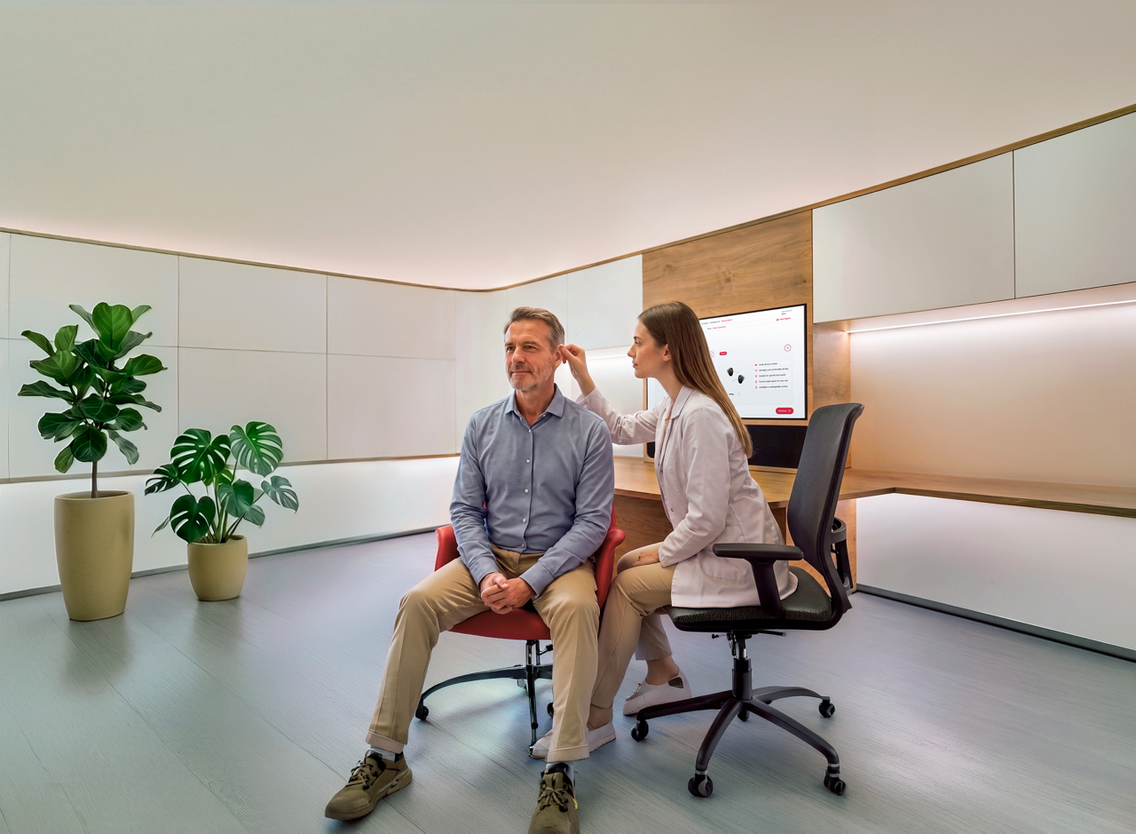 Woman examining man's ear in modern clinic