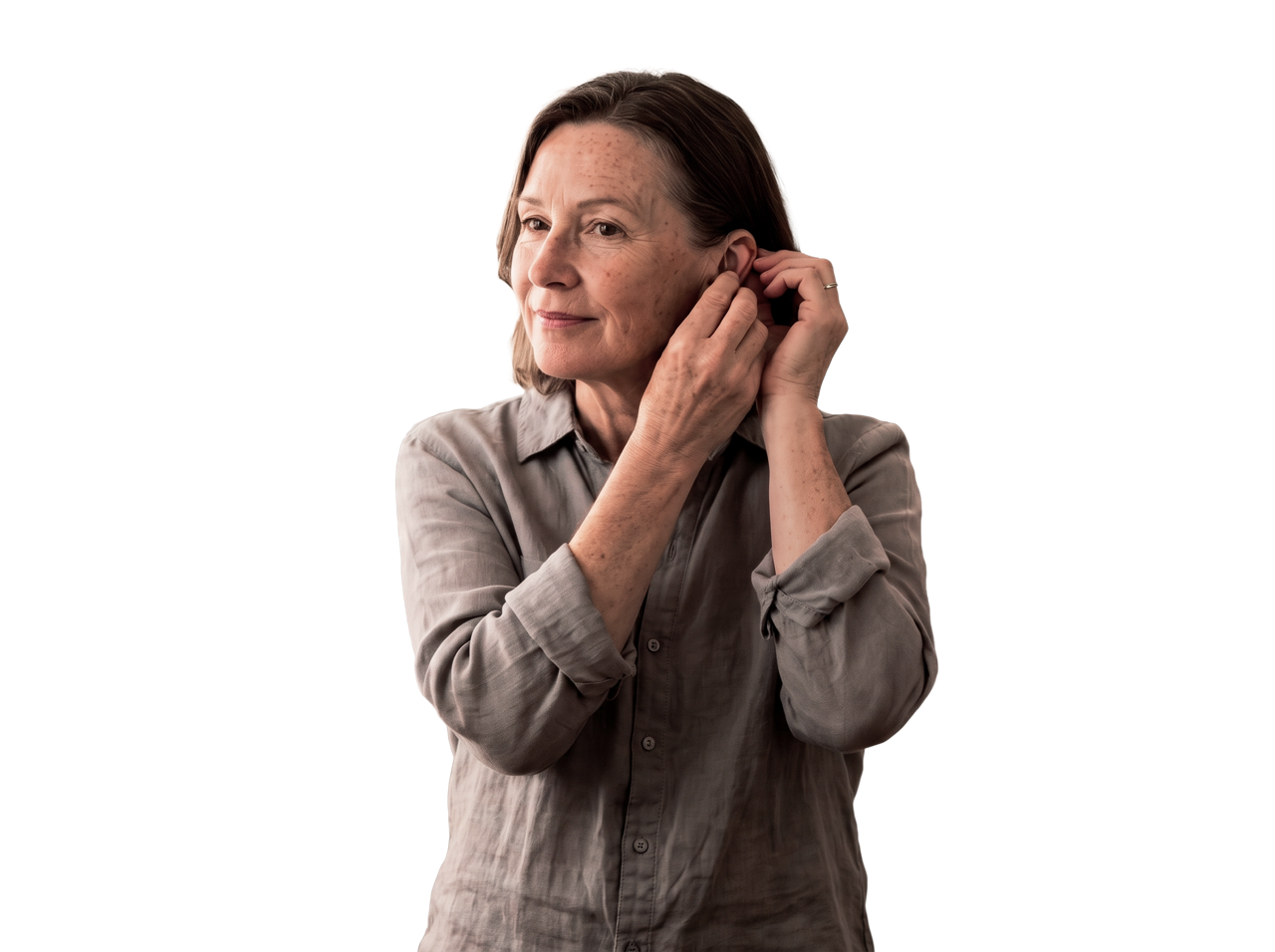 Mature woman adjusting hearing aid device
