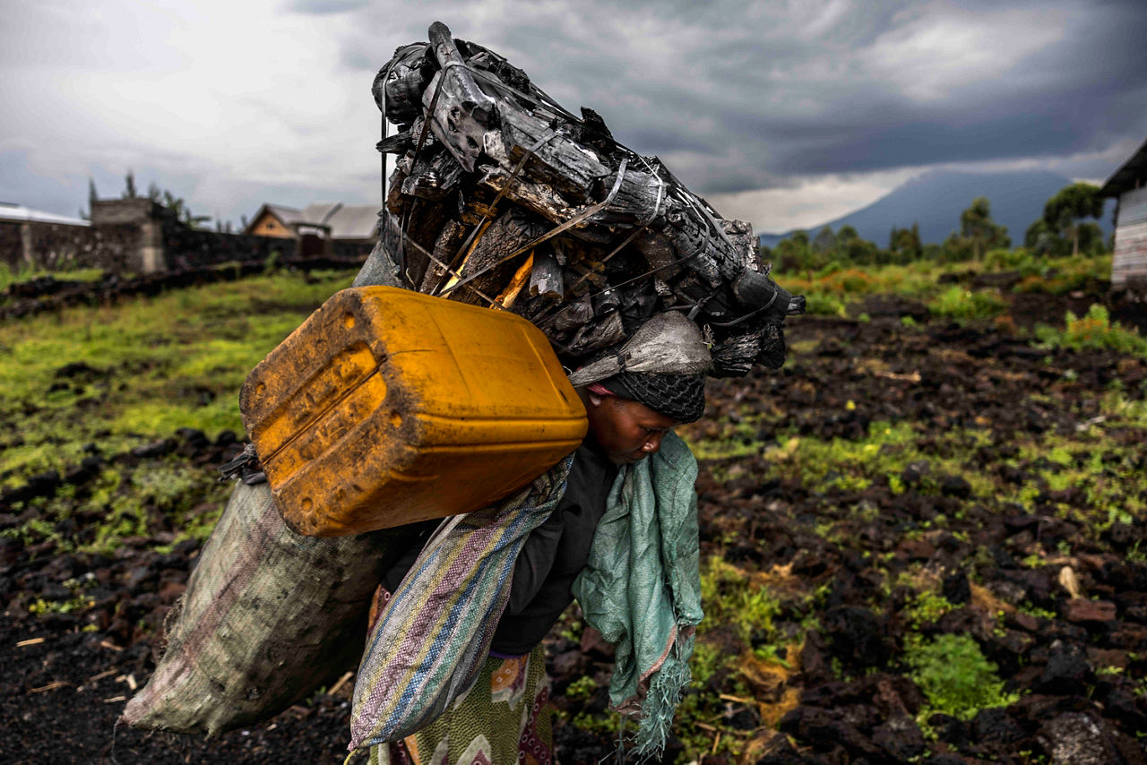 RD Congo 2021, Marché de Rusayo en lisière du Parc des Virungas, ces femmes marchent 8 heures pour rejoindre les fours qui sont à l’intérieur du parc des Virunga et ramener les sacs de 75 kg de « munzeze » (charbon de bois de première qualité) sur le dos. Elles subissent souvent les viols de la part des charbonniers issues des FDLR milice hutus réfugiés dans le parc