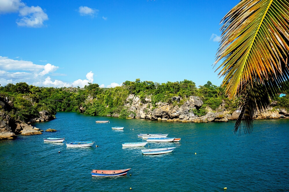 Eleven fishing boats anchored on the rocky shoreline of Boca de Yuma, Dominican Republic.
