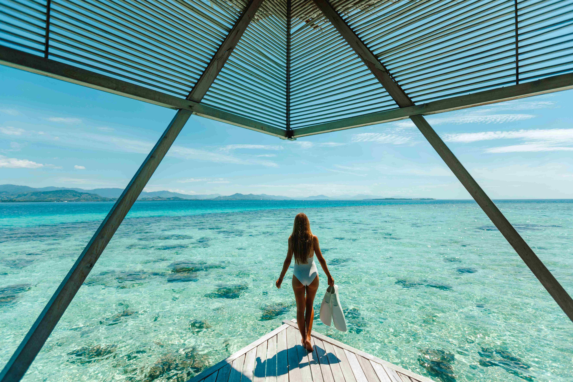 Activities in the Maldives: Woman in which bathing suit on a pier overlooking the sea