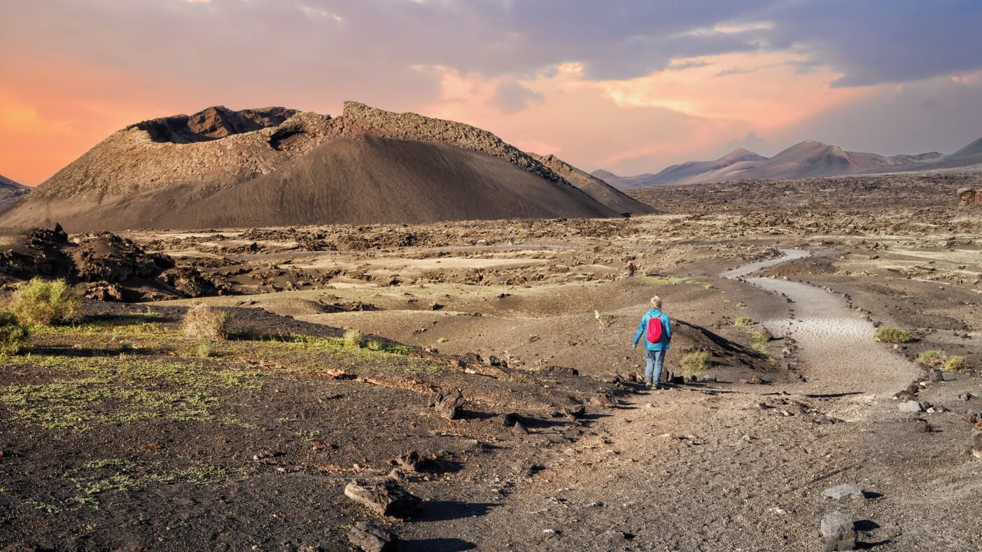 Hiking: A woman hiking across the volcanic landscapes of Lanzarote