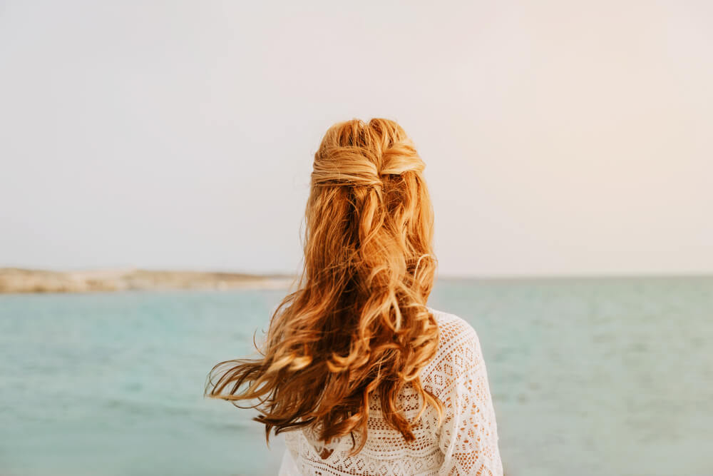 After beach hair care: A woman with her hair down looking out to sea