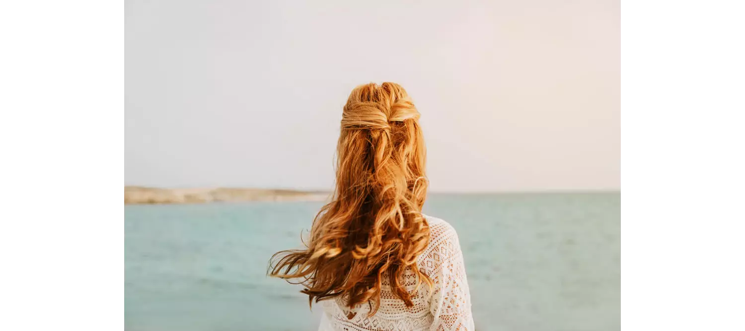 After beach hair care: A woman with her hair down looking out to sea
