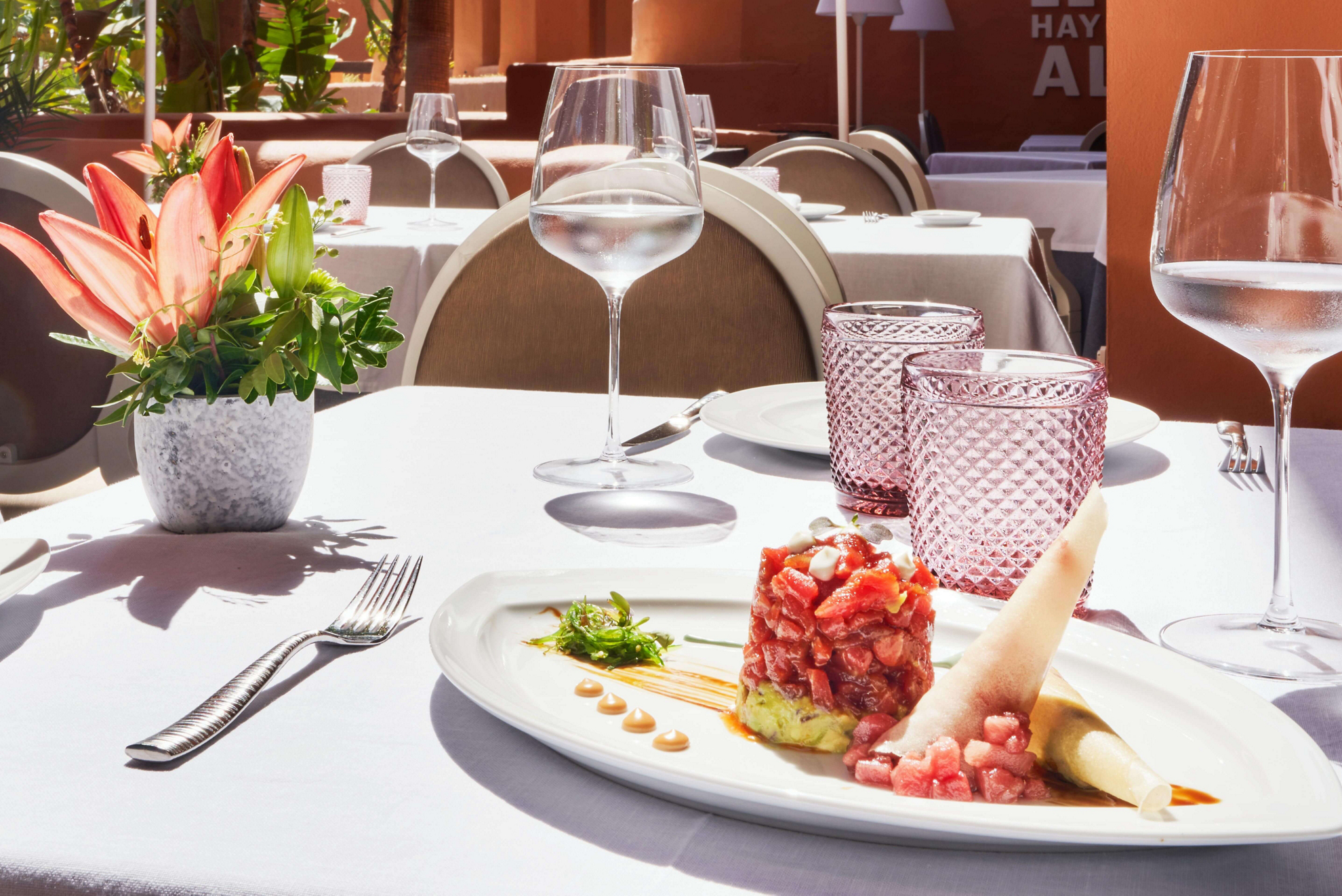 Almadraba-Thunfisch auf einem Teller mit Restaurant im Hintergrund.
