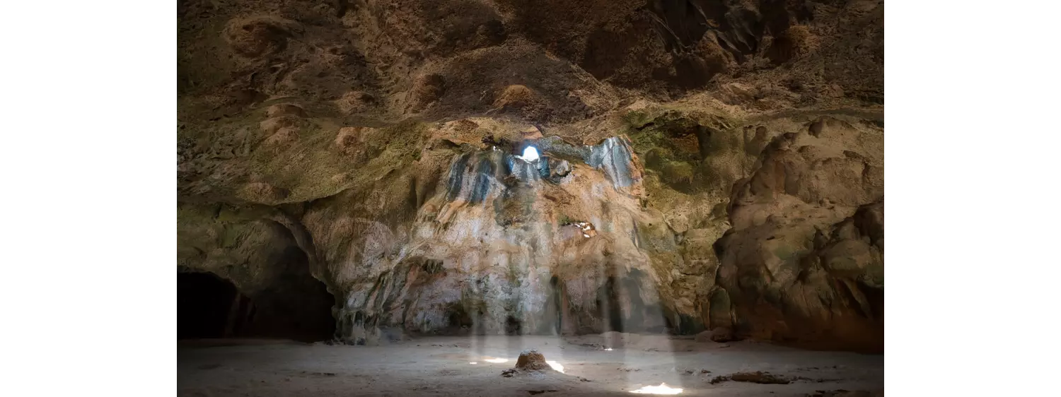 Quadirikiri Cave in Aruba with natural light filtering through its limestone windows.