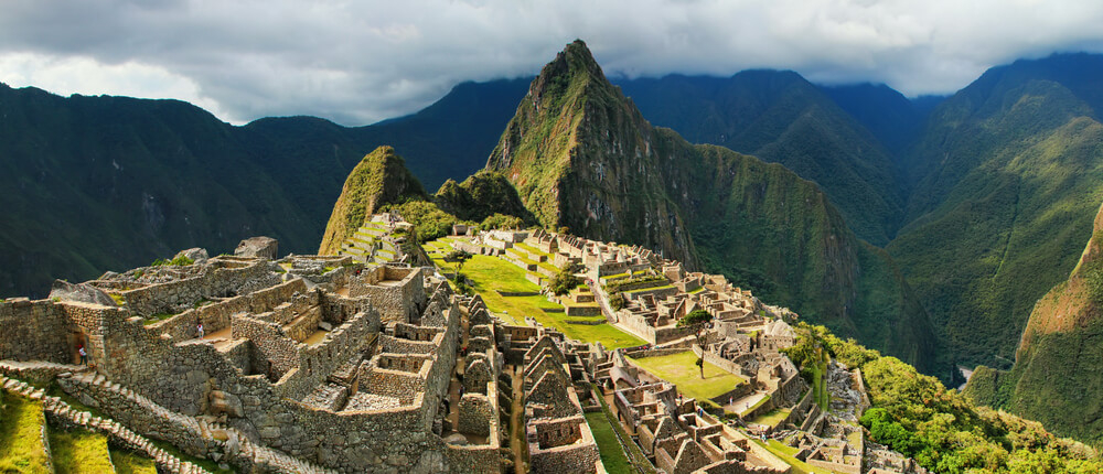 Blick über die Ruinenstadt Machu Picchu mit den Anden im Hintergrund.