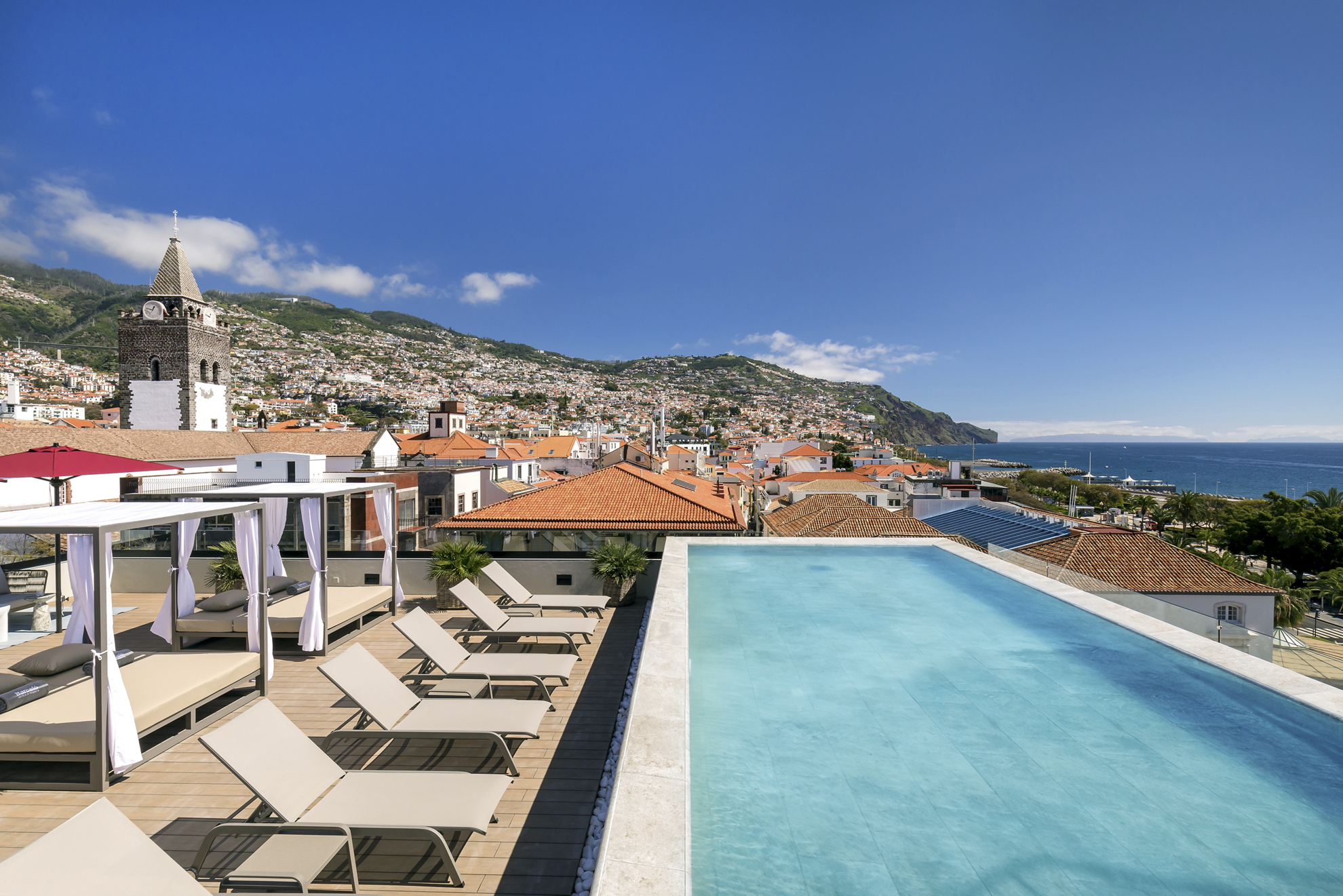 Babymoon-Urlaubsziele: Blick auf die Stadt Funchal von einer Terrasse mit balinesischen Betten.