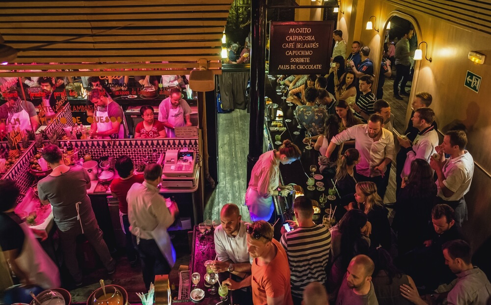 Barcelona nightlife: A group of people eating in a market at night in Barcelona