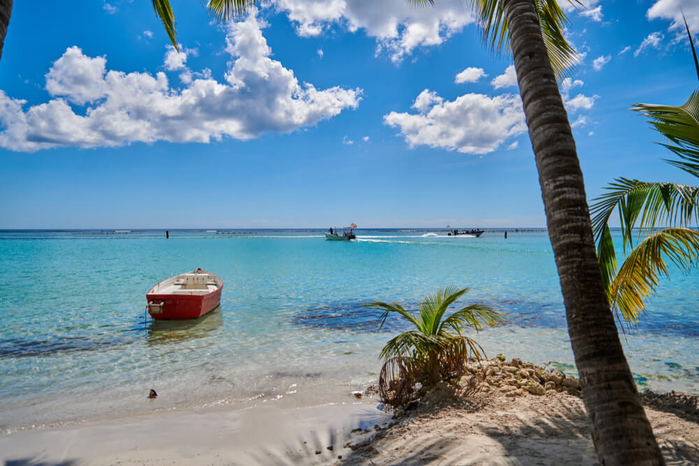 A small boat floats in the waters of Boca Chica, one of the best beaches in the Dominican Republic.