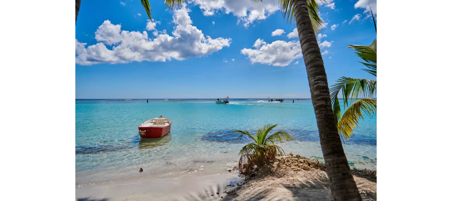 A small boat floats in the waters of Boca Chica, one of the best beaches in the Dominican Republic.