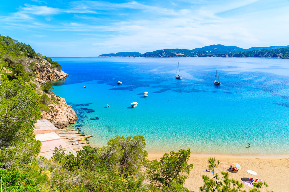 Cala San Vicente: Wide open bay with turquoise water dotted with fishing boats 