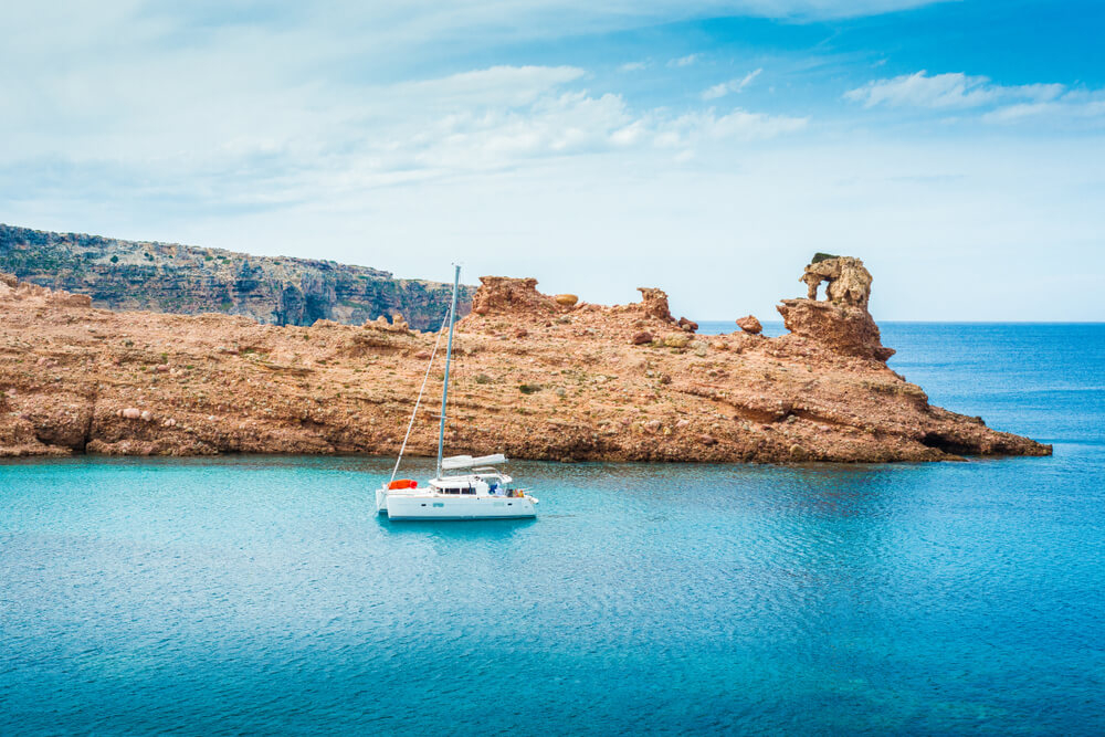 Best calas menorca: Sailing boat on the azure waters of Cala Morell