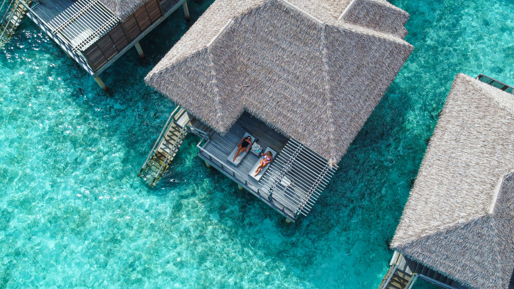 Best honeymoon destinations: A Maldives ocean villa with a couple on the terrace