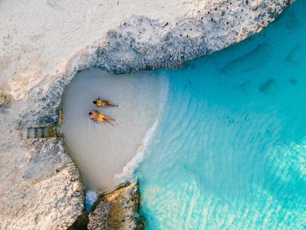 Best islands for a honeymoon: A white sand cove with a couple on the sand seen from above