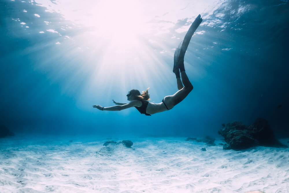 Best places for scuba diving: girl free diving in the ocean
