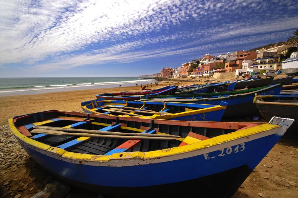Best places to visit in Morocco: A golden beach in Taghazout with fishing boats