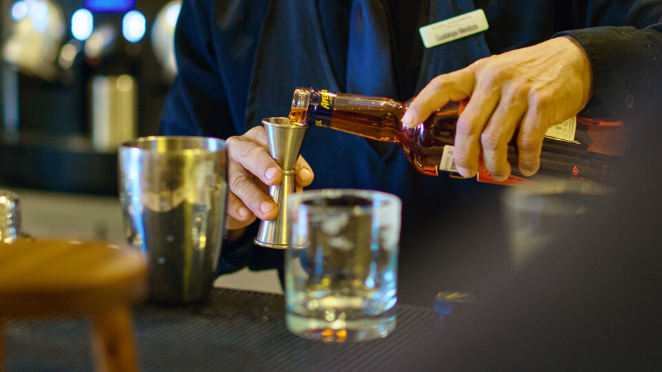 Royal Hideaway Playacar: A waiter pouring alcohol into a measure at a bar