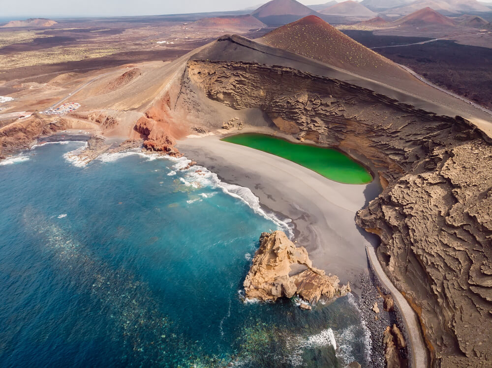 A bird’s eye view of the black volcanic sand and green water of Charco de los Clicos