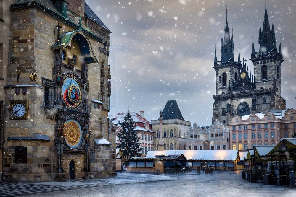 Prague winter breaks: Snow-covered square and astronomical clock in Prague