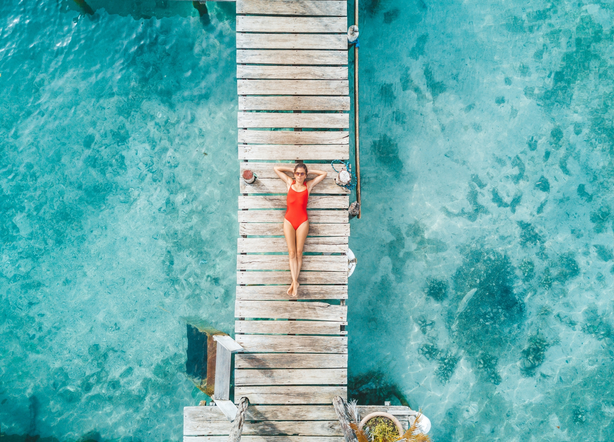 Aerial shot of womann relaxing in a water bungalow