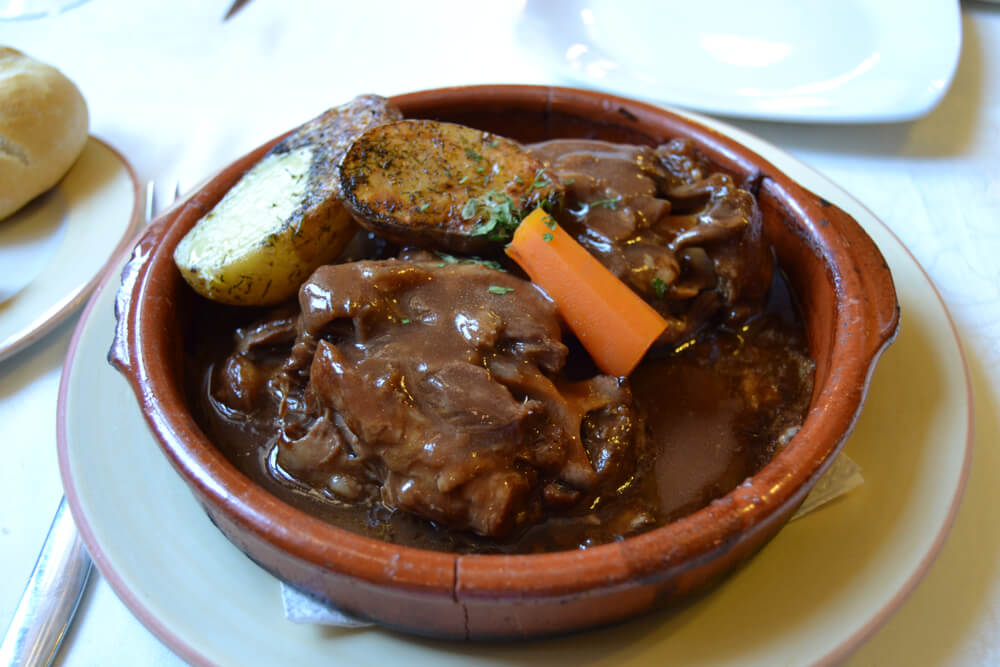 Carne de cabra: A bowl of goat’s meat covered in a rich and creamy sauce